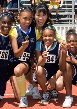 Elementary school girl's track and field team happily displaying their medals