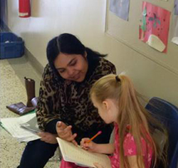 Parent Naghma working on reading with a student in grade 1 at John A. Leslie
