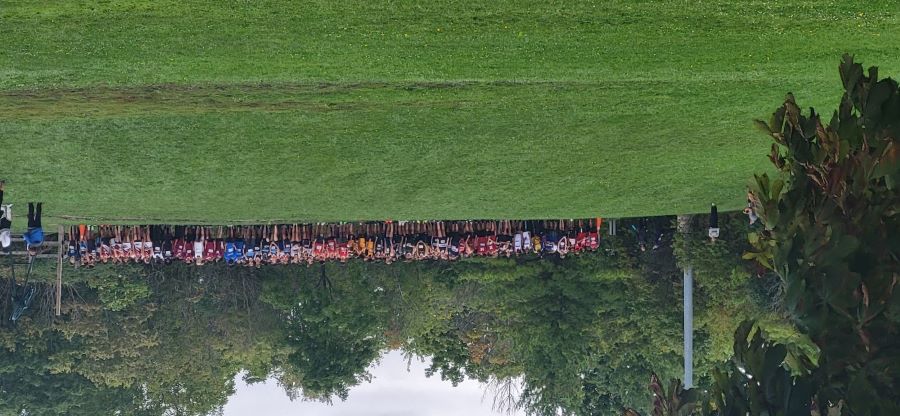  Hundreds of students line up at the starting line of the cross country race at the top of a hill.