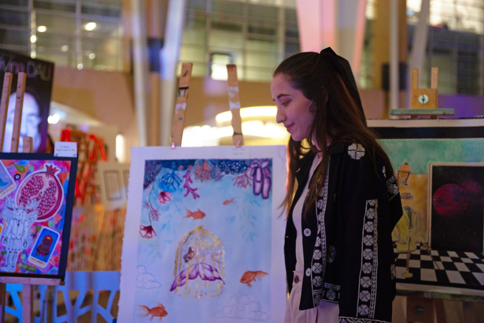 A student standing beside their artwork at Brookfield Place.